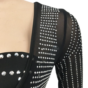 Détail de robe en tulle noir avec des strass argentés scintillants sur l'épaule droite