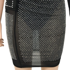 Détail de la robe courte en maille noire avec strass argentés denses et tissu transparent