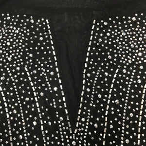 Dettaglio dello scollo a V in rete con strass scintillanti e decorazioni in cristallo
