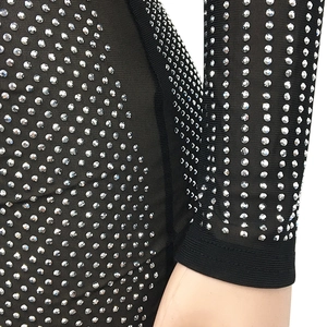 Détail de strass argentés sur tissu en maille noire avec artisanat de couture précis