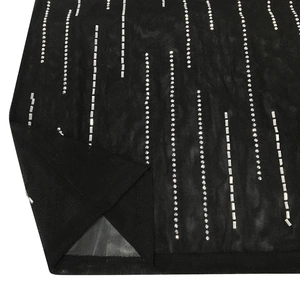 Dettaglio del tessuto a rete nero con strass argentati verticali e spacco laterale
