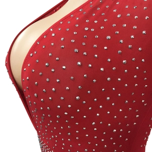Dettaglio dell'abito rosso con scollo a V e strass argentati su tessuto a rete