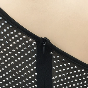 Détail macro du tissu en maille noire avec strass argentés et fermeture éclair invisible
