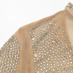 Detail of skin-toned mesh fabric featuring shimmering iridescent rhinestones on the shoulder