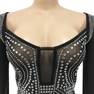 Close-up of black sexy mesh dress featuring intricate rhinestone patterns and plunging neckline