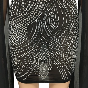Close-up of intricate silver rhinestone wave patterns on a black sexy mesh party dress