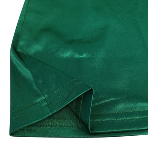 Close-up of double-stitched hem on dark green glossy satin fabric dress detail