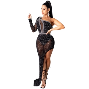 Close-up of asymmetric black dress featuring sheer mesh sleeve and sparkling rhinestones