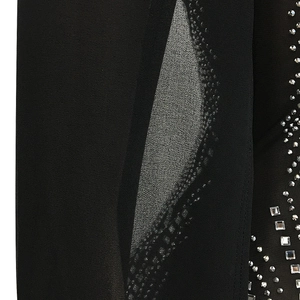 Macro detail of rhinestone waves and mesh patchwork on sexy black club dress