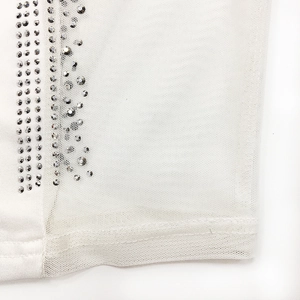 Close-up of white mesh fabric with silver rhinestone embellishments and delicate stitching