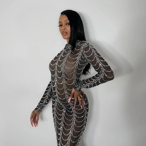 Detail of sheer black mesh dress featuring shimmering silver rhinestones in wave patterns