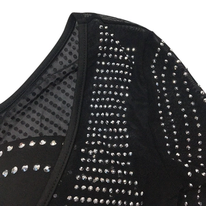 Détail du tissu en maille noire avec strass argentés sur la robe sexy à une épaule