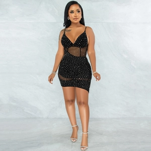 Close-up of sparkling silver rhinestones and sheer mesh patchwork on a black mini dress