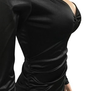Detail view of the sleek black long sleeve V-neck dress featuring elegant side ruching detail