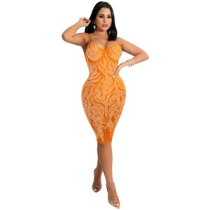 Detail van de oranje bodycon jurk met golvende strass patronen en hartvormige hals