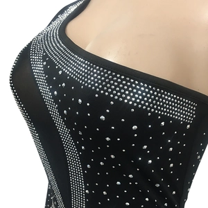 Detail of black mesh dress featuring shimmering silver rhinestones and square neckline