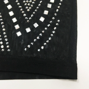 Detail of black mesh fabric with silver rhinestone geometric V-pattern for sexy dress