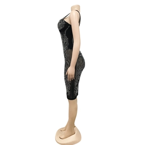 Detail van zwarte bodycon jurk met zilveren strassteentjes en transparant gaas