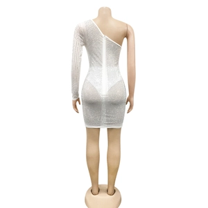 Détail du tissu en maille blanche avec strass brillants sur la mini-robe asymétrique