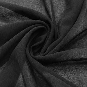 Close-up of lightweight black chiffon fabric texture with soft wavy drapes and sheer finish