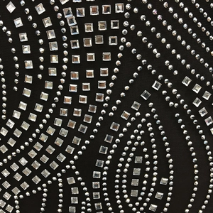 Macro detail of sexy mesh dress fabric featuring sparkling rhinestones on black netting
