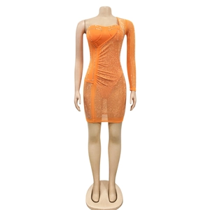 Détail de la robe en maille orange avec strass argentés et textures drapées élégantes