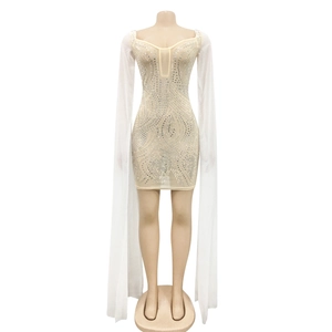 Detailed view of silver rhinestones in swirl patterns on a nude bodycon mesh dress