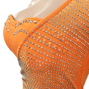 Détail du tissu en maille orange avec strass argentés sur une robe sexy à une épaule
