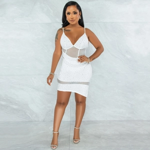 Detail of white mini dress featuring sparkling rhinestones and sheer mesh patchwork inserts