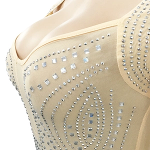 Detailed view of nude mesh fabric with silver rhinestones and wave patterns on a V-neck dress