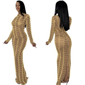 Detail view of skin-tone mesh maxi dress with layered gold bead chains and sheer sleeves