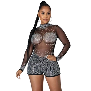 Nahaufnahme eines schwarzen Netz-Jumpsuits mit Langarm und glitzerndem Strassbesatz