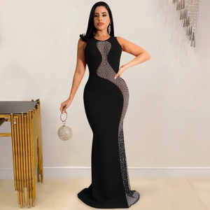 Detailed view of sheer mesh patchwork and shimmering rhinestones on a black evening gown