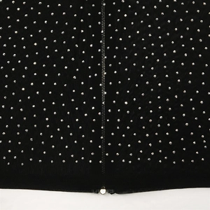 Detail of silver rhinestones and metal zipper on black mesh evening dress fabric