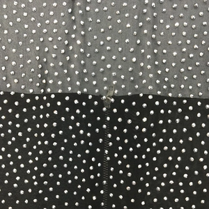 Detail of black mesh fabric featuring high-density silver rhinestones and seam line