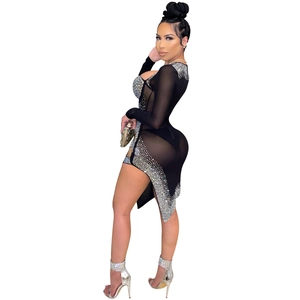 Détail d'une robe de soirée en mesh noir transparent avec strass et fente latérale
