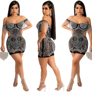 Detail of black mini dress featuring silver rhinestones and long metallic shoulder tassels