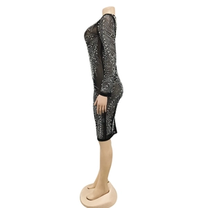 Detail of sheer black mesh dress featuring shimmering rhinestones in wave patterns