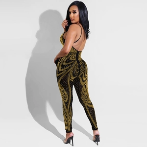 Detail view of black mesh jumpsuit featuring shimmering gold rhinestones and an open back design