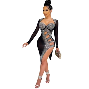 Détail de mini-robe noire avec strass argentés, découpe latérale et manches longues en résille