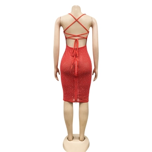 Macro detail of red backless party dress featuring criss-cross straps and shimmering rhinestones
