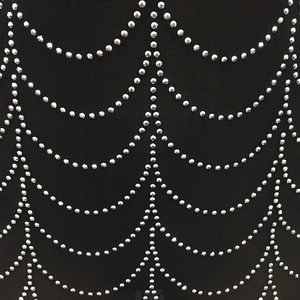 Macro detail of silver rhinestones in draped patterns on black mesh sheer dress fabric