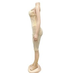 Detailweergave van strasspatronen en mesh-stof op een sexy beige nauwsluitende jurk