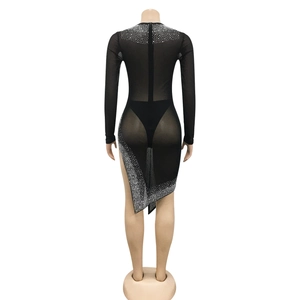 Détail de la robe en maille noire avec strass scintillants et ourlet asymétrique chic