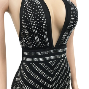 Detailed close-up of sparkling silver rhinestones on a black deep V-neck evening dress