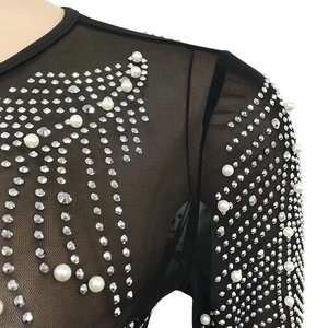 Close-up of black mesh top featuring intricate white pearls and silver rhinestones