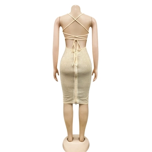 Detailed back view of a beige backless bodycon dress with crisscross straps and rhinestones
