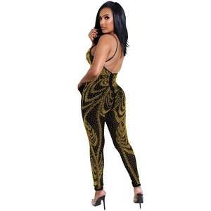 Detail of slim-fit backless jumpsuit with gold rhinestones on black mesh fabric