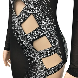 Détail d'une robe de soirée noire avec strass argentés et découpes géométriques