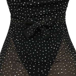 Close-up of black mesh dress with silver rhinestones and waist bow detail